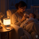 Mãe dando mamadeira ao bebê à noite com a Lunalu acesa